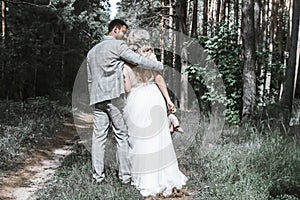 The bride and groom embrace in the forest on the wedding day. wedding ceremony. selective focus. film grain