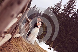 Bride and groom embracing near forest