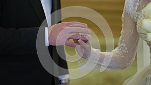 The bride and groom exchange rings at the indoors wedding ceremony.