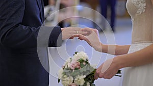 The bride and groom exchange rings at the indoors wedding ceremony.