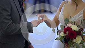 The bride and groom exchange rings at the indoors wedding ceremony.