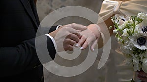 The bride and groom exchange rings at the indoors wedding ceremony.