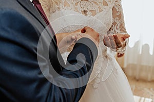 The bride and groom exchange rings. A man puts a wedding ring on a woman& x27;s hand.