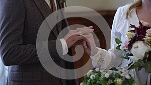 Bride and groom exchange wedding rings at ceremony. Lovely couple