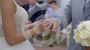 Bride and groom exchange wedding rings at ceremony. Lovely couple