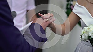 Bride and groom exchange wedding rings at ceremony. Lovely couple