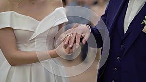 Bride and groom exchange wedding rings at ceremony. Lovely couple