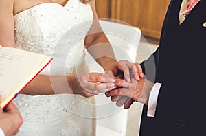 Bride and groom exchanging the wedding rings in church during the wedding ceremony