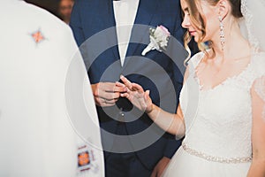 Bride and groom exchanging wedding rings. Stylish couple official ceremony