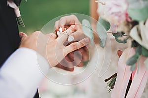 Bride and groom exchanging wedding rings. Stylish couple official ceremony