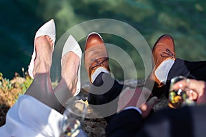 Bride and groom feet on a sea background.