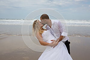 Bride and groom getting married by the beach