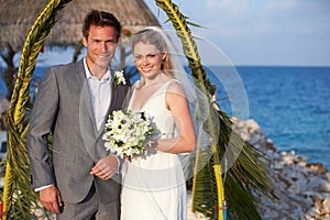 Bride And Groom Getting Married In Beach Ceremony