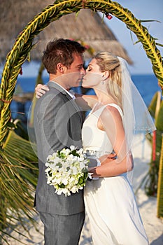 Bride And Groom Getting Married In Beach Ceremony