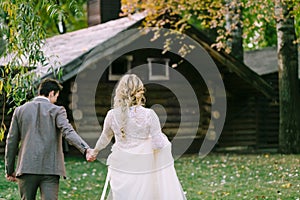 Bride and groom go to wooden home in the forest. Autumn wedding. Artwork