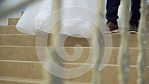 Bride and groom goes down stairs in a luxurious palace or mansion.