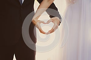 The bride and groom hands forming heart shape a symbol of love