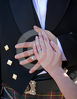 Bride and groom hands resting on groom stomach