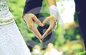 Bride and groom hands in the shape of heart