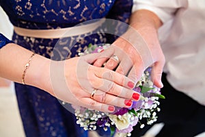 Bride and groom hands with wedding rings