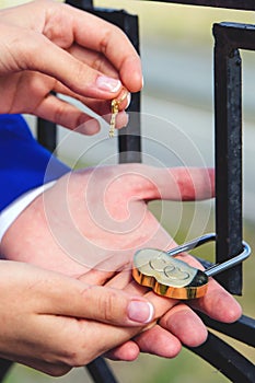 The bride and groom hang the wedding lock on the bridge. The keys and the padlock symbol of love and fidelity. Wedding