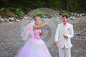 Bride and groom having fun with soap bubbles