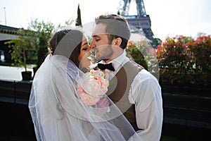 Bride and groom having a romantic moment on their wedding day in Paris, in front of the Eiffel tour