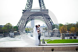 Bride and groom having a romantic moment on their wedding day in Paris, in front of the Eiffel tour