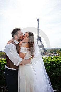 Bride and groom having a romantic moment on their wedding day in Paris, in front of the Eiffel tour