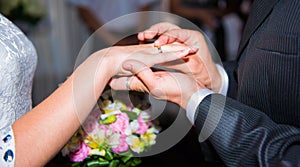 Bride and groom hold bouquet of flowers with rings