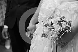 The bride and groom hold each other`s hands, a gold ring on the bride`s finger