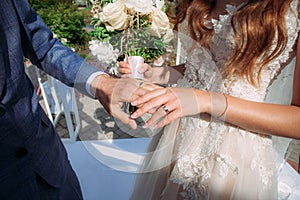 The bride and groom hold each other's hands at the wedding ring exchange ceremony