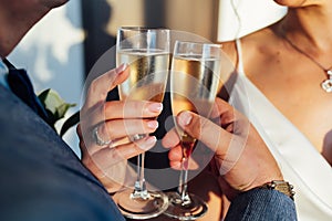 Bride and groom hold in their hands glasses with wine