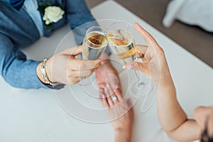 Bride and groom hold in their hands glasses with wine