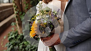 the bride and groom hold a wedding bouquet together at the ceremony