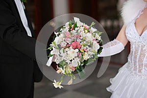 Bride and groom holding bridal bouquet close up