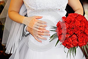 Bride and groom holding bridal bouquet close up