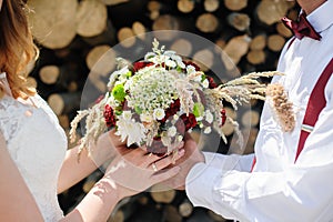 Bride and groom holding bridal bouquet close up