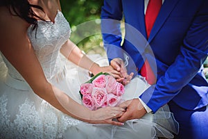 Bride and groom holding bridal bouquet close up