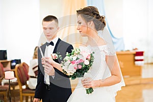 Bride and groom holding candles in church