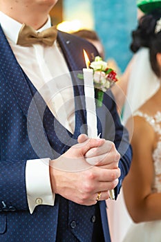 Bride and groom holding the candles. Close up.