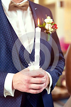 Bride and groom holding the candles. Close up.