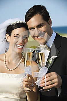 Bride and groom holding champagne.