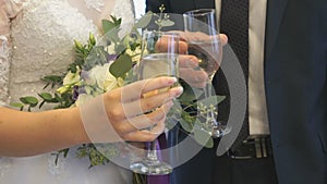 Bride and groom holding glasses of wine. Close-up