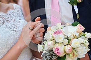 Bride and groom holding hands with bridal bouquet