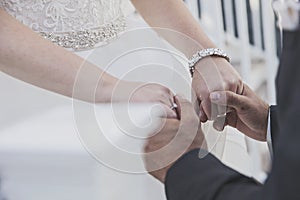 Bride and groom holding hands close-up