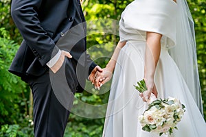 the bride and groom are holding hands, without faces