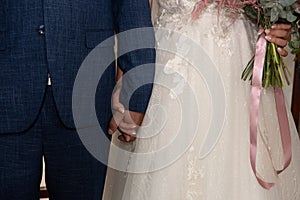 Bride and groom holding hands. Just married couple. Love relationship, husband and wife