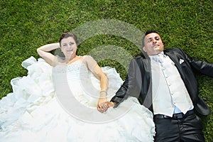 Bride and groom holding hands on lawn