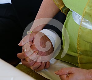 Bride and groom holding hands during marriage ceremony in civil registry office